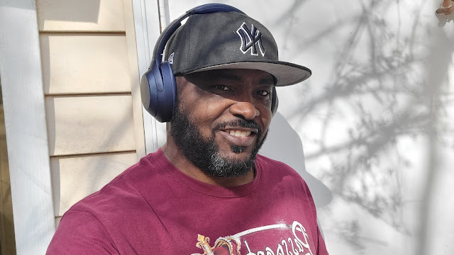 Man smiles with Sony XM4 headphones