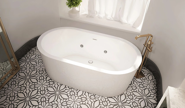 Freestanding oval bathtub with jets on a patterned tile floor in a white and gray bathroom.