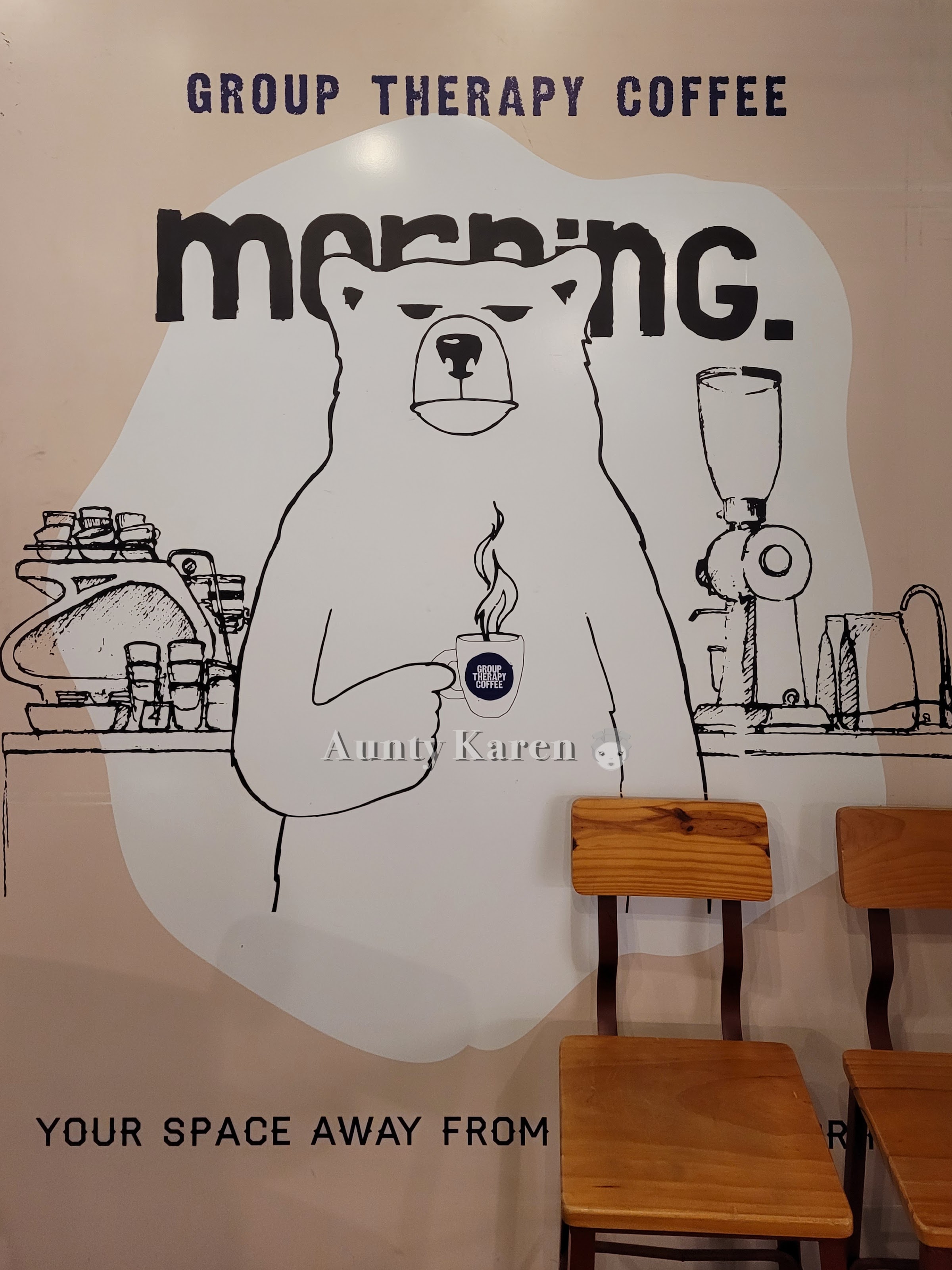Wall mural showing a bear holding a cup of coffee at the entrance of Group Therapy @ Katong V