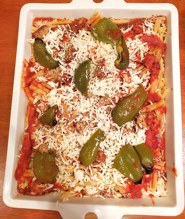 this is a casserole of cavatelli pasta with broccoli rabe and pepper topped with shredded mozzarella