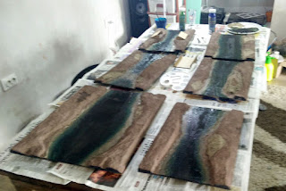 Six river sections all painted and drying on the dining table