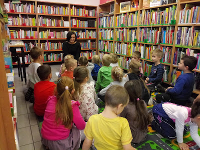 Zdjęcie przedstawiajace bibliotekarza opowiadającego dzieciom o bibliotece