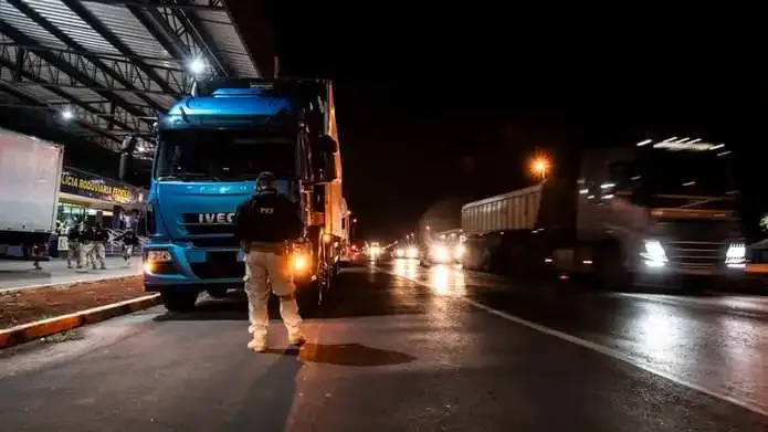 Agentes da PRF abordando caminhões para fiscalização em rodovia