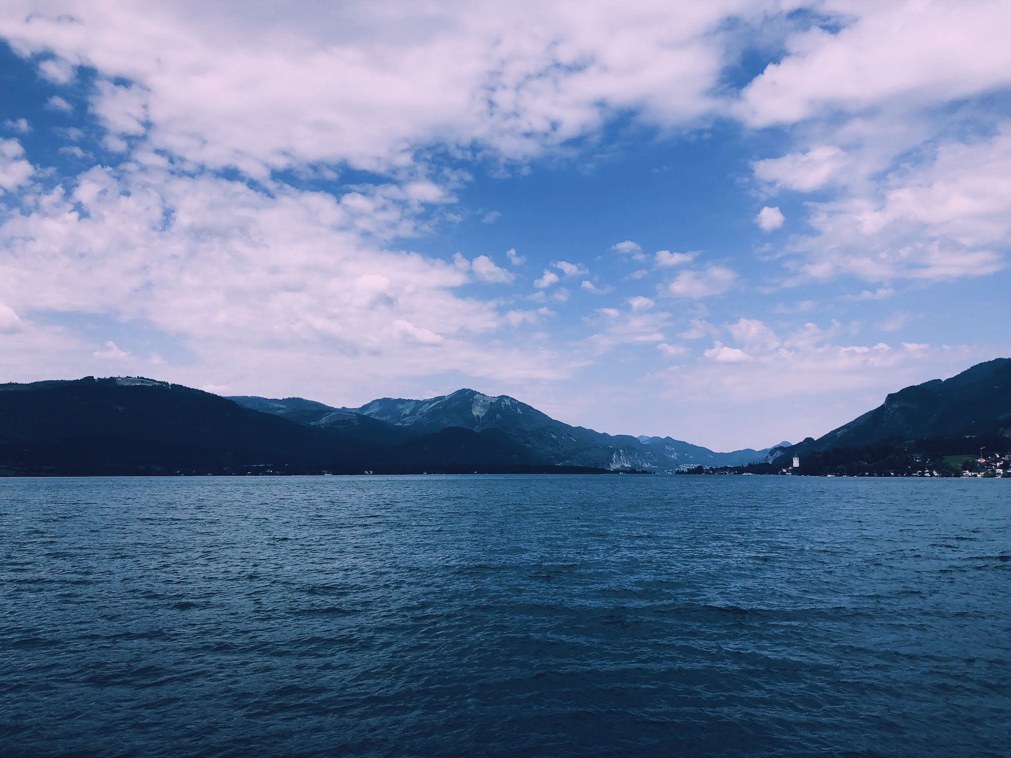 Bergen landschap met wolkenhemel en helderblauw water.