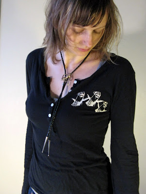 A portrait of Aramee Diethelm wearing a long sleeve shirt with heath hens that she designed and hand screen-printed.