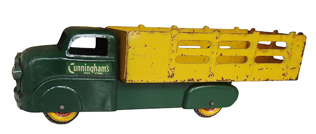 Marx toy stake truck bearing "Cunningham's Drug Store" logo, with Marx metal wheels.