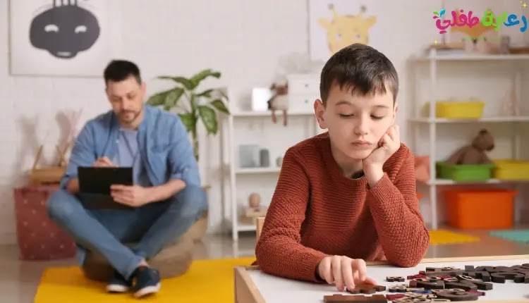 صورة طفل يلعب بمفردة في هدوء، وخلفه والده الذي يجلس على الاريكة وبيده محمولة الخاص، كتعبير عن رغبة أطفال التوحد في الإنعزال.