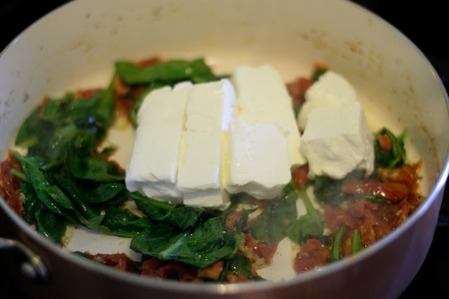 The cream cheese being added to the pan. 