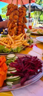 Porcion de camarao a la grega en la que se aprecia el acompañamiento de papas fritas y la ensalada que lo acompañan.