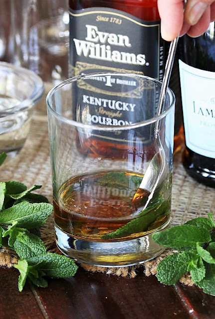 Muddling Mint Into Bourbon in a Glass Image