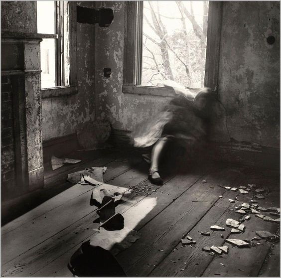 Black & White photograph of a woman whose top half is blured. Take by Francesca Woodman