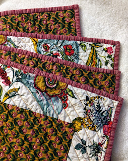 The folded quilt shows the front, back and binding. The back of the quilt is the same fuchsia flowers on mustard that is the background of the Lone Star on the front.