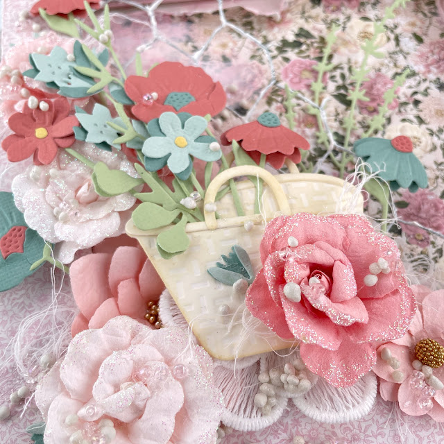 Flower Basket reverse mixed media canvas created with: Sizzix creamy matte paint in cherry blossom, sequin mix in ballet slipper, floral vessels, in the meadow, woodland stems die, muted cardstock, white texture roll; Scrapbook.com cloud whip; Tim Holtz linen distress oxide; Prima miel paper, flowers, art stones