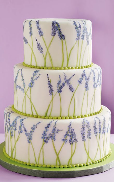 Three tier white round wedding cake decorated with lavender flowers