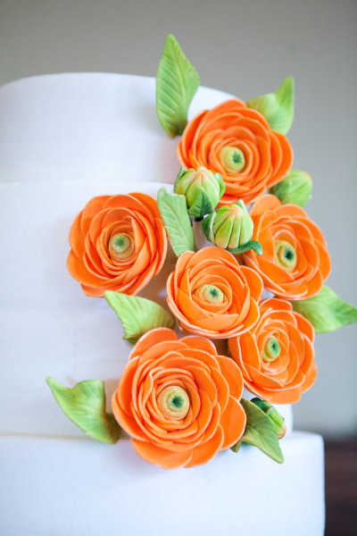 Bright Orange Flowers Beautiful wedding cake set over four round tiers in 