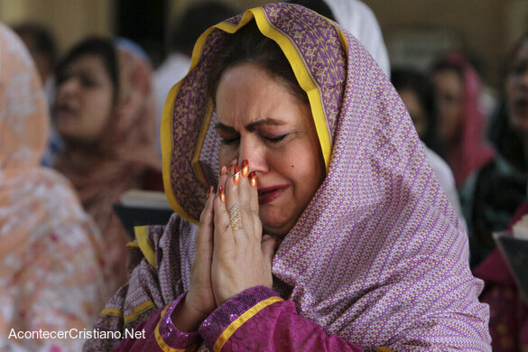 Mujer cristiana orando en iglesia de Pakistán