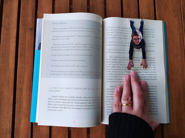 marcador de livro feito a partir de uma fotografia de uma criança, que parece pendurada na parte de cima do livro