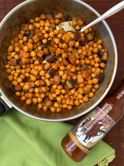 Pan with the finished chickpea and eggplant taco filling and a jar of the curry barbeque sauce.