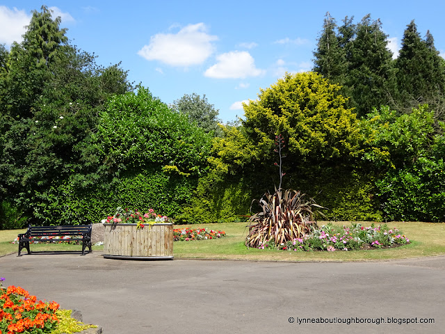 Trees in leaf, and flowers blooming in park setting