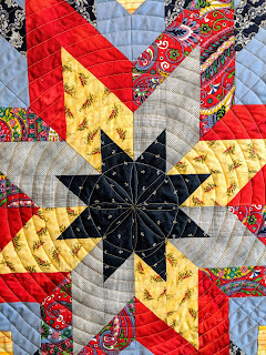 An orange peel design surrounded by spiral quilting on a Lone Star quilt