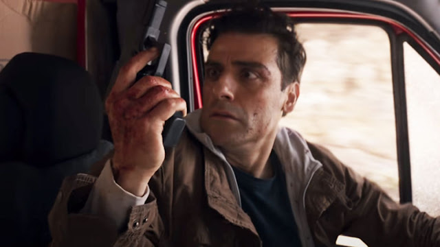 A man driving a truck stares at a gun