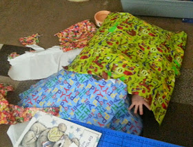 4 year old hiding in wrapping paper