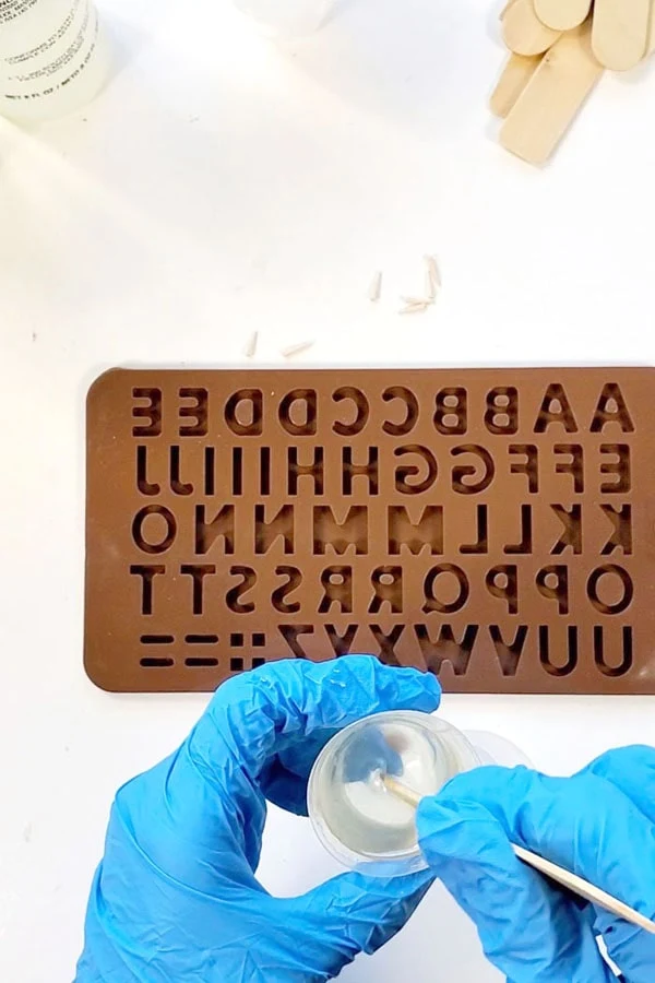 STEP 3: FILLING SILICONE MOLD   After the proper 2 phase mixing process for the Fast Cast Resin, use the mixing stick to pour the resin into the mold.    This part can get tricky and messy because the resin thickens and sets up very quickly.    I have a solution for this, that I call “editing”…but you can mix up less resin and work a letter or 2 at a time if that feels better to you.