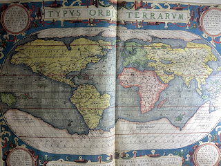 A two page spread showing a late 16th century map of the globe.