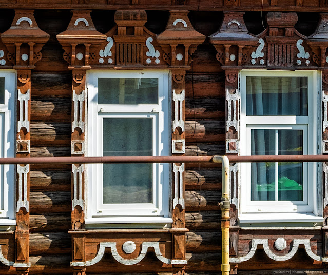 Окна деревянного дома с наличниками с пропильной резьбой