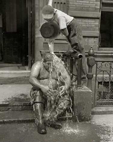 صبي يصب الماء على عامل في جو حار جداً في نيويورك عام 1947