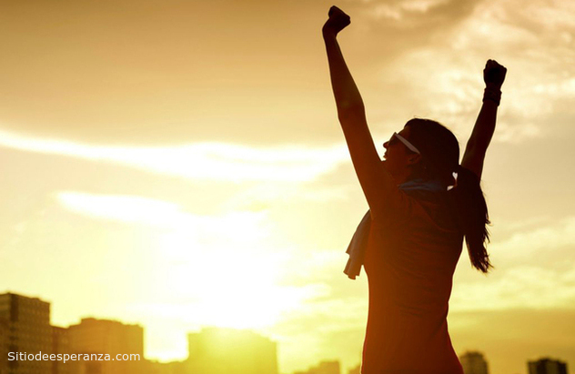 Mujer feliz levantando las manos al cielo