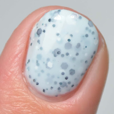 light blue nail polish with black glitter close up