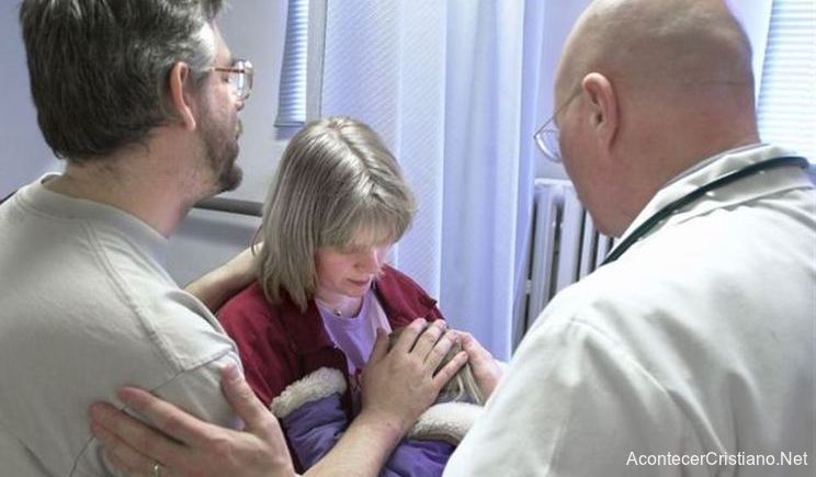 Médicos orando por paciente en hospital