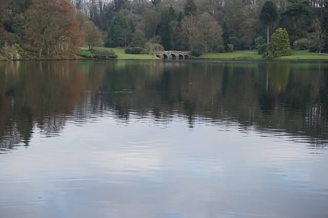 View of the lake at Stourhead, with a stone bridge in the distance