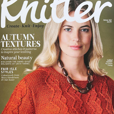 Magazine cover with model wearing a hand knitted sweater looking at camera