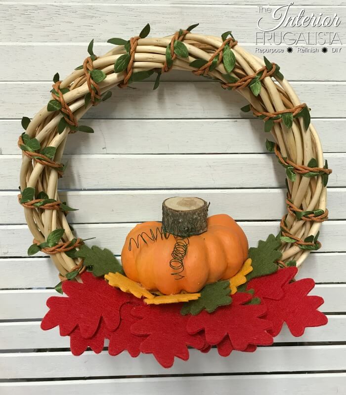 Turn inexpensive dollar store finds into an adorable small DIY Fall Pumpkin Wreath and it's so quick and easy to make in five minutes or less.