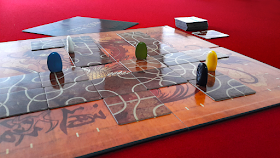 A game of Tsuro in progress. The photo shows the board, with several tiles laid out upon it, and the players' pieces on the tiles ready for the next player's turn.