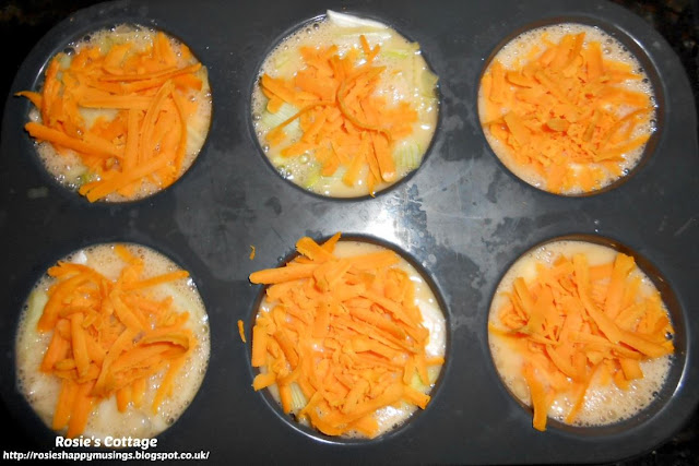 Egg-stra Yummy, Cheesey Egg Muffins... beat the eggs in a bowl and then carefully pour into the muffin tray cups, completely covering the mozzarella and spring onions/scallions.  Finally top with a little grated cheese before baking.