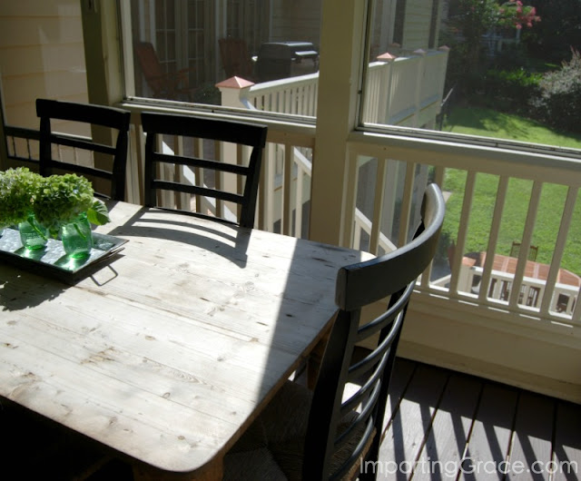 From screened porch dining area, you can see adjacent deck and patio below