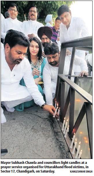 BJP leader and former MP Satya Pal Jain, Mayor Subhash Chawla and councillors light candles at a prayer service organised for Uttrakhand flood victims, in Sector 17, Chandigarh, on Saturday.