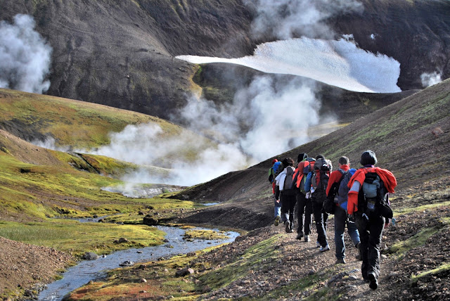 caminando entre fumarolas de tierra volcánica durante el trekking del laugavegur, en islandia