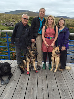 Bob, Mike, Gena and Sue on a bridge with their guide dogs and GPS