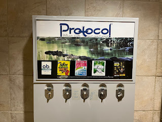 tampon machine offering super tampons, sour patch kids, ultra thin panty liners, life savers mints, and fake gold jewelry