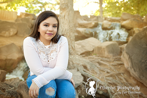 Professional photograph of an Atrisco high school senior on top at the UNM Duck Pond Albuquerque