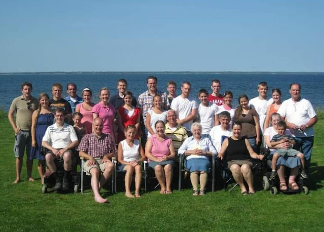 large family picture with ocean behind them