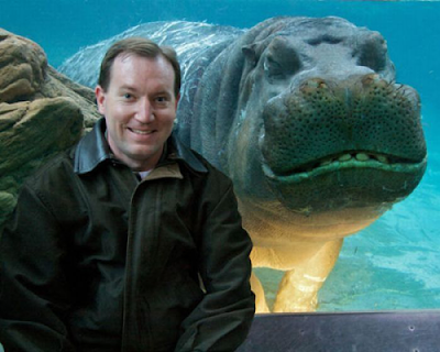 Hombre posando con hipopotamo