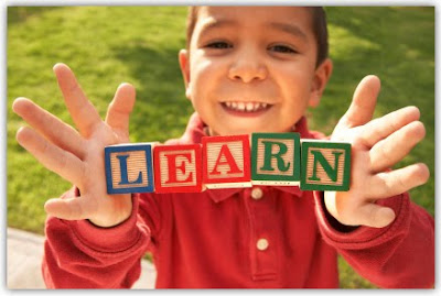 little boy hold letter blocks that spell learn