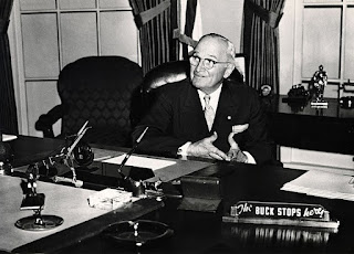 Harry Truman poses for a photograph at the recreation of the Truman Oval Office at the Truman Library in 1959.