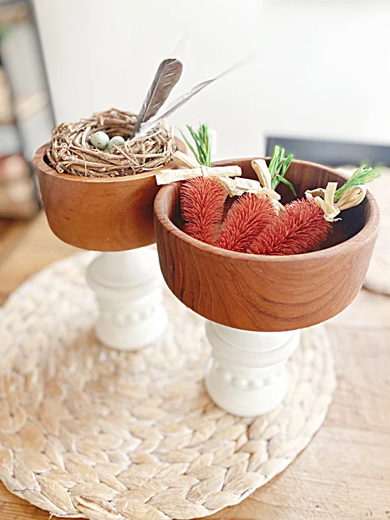 wooden bowls on legs with carrots and nest