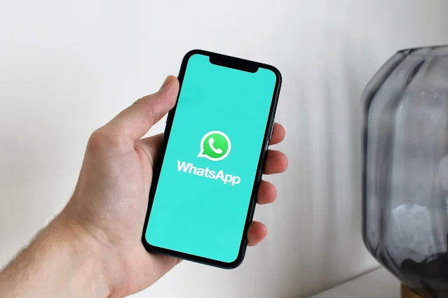 Man hand holding phone shows WhatsApp logo